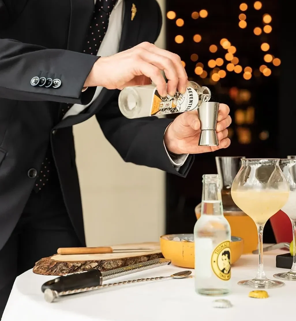 Cédric, sommelier professionnel, animant un atelier œnologique avec préparation de cocktails lors d’un apéro dînatoire convivial.